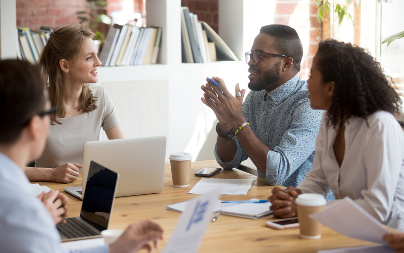 African Male Employee speaking sharing ideas at a diverse team meeting