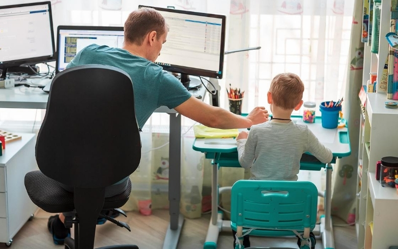 Dad working remotely while with his kid