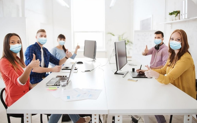 Team wearing protective masks in a conference room setting