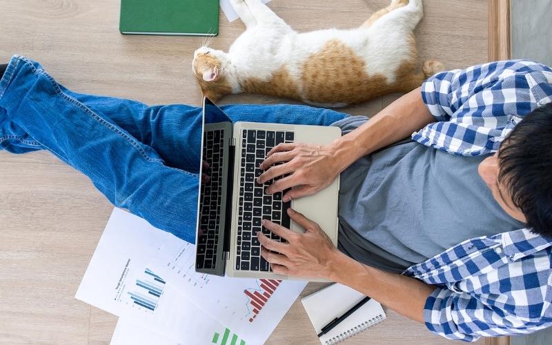 man sitting typing on laptop