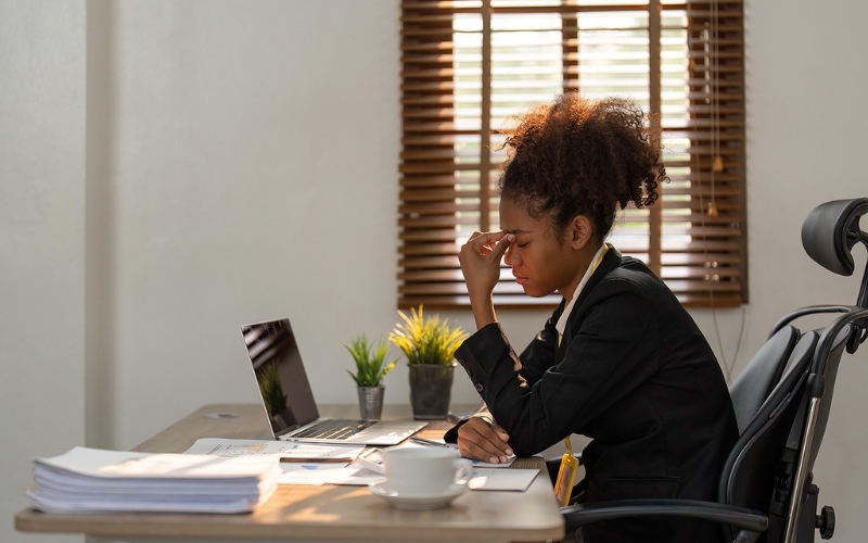 Professional woman sitting at desk looking tired