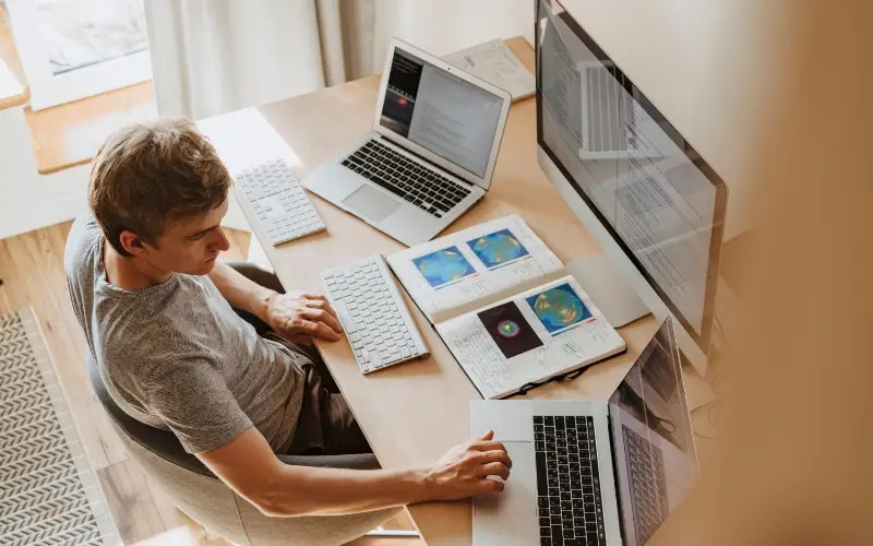 independent contractor working at desk with multiple screens