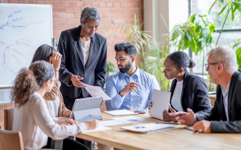 people sitting around a conference table reviewing documents